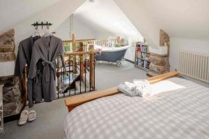 a bedroom with a bed and a tub in a attic at Rosie's Barn in Penrith +127 photos