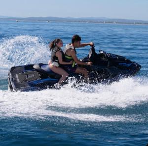 two people riding on a jet ski in the water at El Candelabro in Pisco