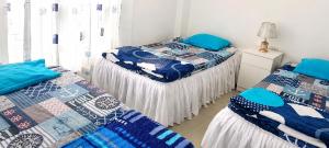 two beds in a room with blue at El Candelabro in Pisco