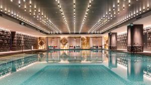 a pool in a hotel with lights on the ceiling at Hotel Indigo Ningbo by IHG in Ningbo