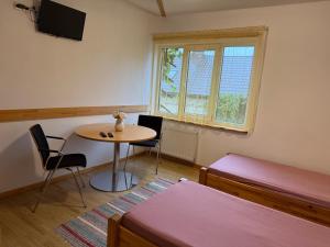 a room with a table and a bed and a table and chairs at Guest House Maija in Ventspils
