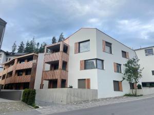 an apartment building with wooden balconies on a street at Casa Rok in Flims