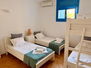 a room with two beds and a bunk bed at Paros Home in Kampos Paros