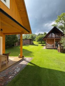 a yard with a wooden pavilion and a house at Domek w Jacni in Jacnia