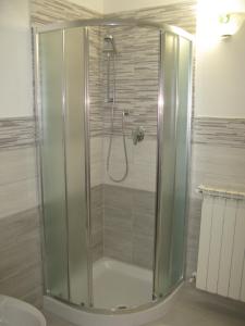 a shower with a glass door in a bathroom at Camera gigli al civico 29 in Collestrada