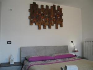 a bedroom with a bed with purple sheets and a wall at Camera gigli al civico 29 in Collestrada