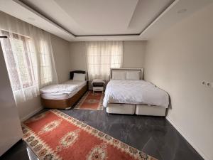 a bedroom with two beds and a rug at Deluxe apart in Pamukkale
