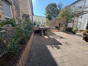a patio with a bench and a brick wall at Auszeit am Brunnen in Mendig