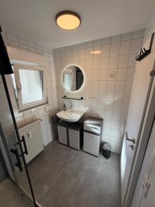a small bathroom with a sink and a mirror at Auszeit am Brunnen in Mendig