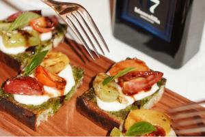 a sandwich with tomatoes and eggs on a plate with a fork at The St. Regis Jakarta in Jakarta