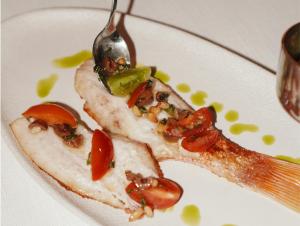 a white plate with a piece of food with a spoon at The St. Regis Jakarta in Jakarta