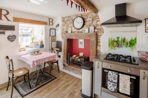 a kitchen with a table and a clock on the wall at Rosie's Barn in Penrith