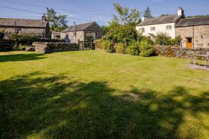 a yard with a large lawn in front of a house at Rosie's Barn in Penrith