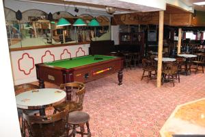 a restaurant with a pool table and tables and chairs at Middlegate Hotel in Pembroke