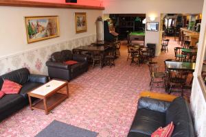 a living room with couches and tables and a bar at Middlegate Hotel in Pembroke
