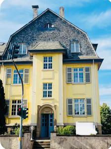 a yellow house with a blue door at Foundry ONE LoftQuartier in Jugenstilvilla in Wittlich