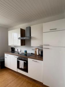 a kitchen with white cabinets and a stove at Foundry ONE LoftQuartier in Jugenstilvilla in Wittlich