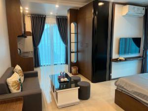 a bedroom with a bed and a couch and a table at Tâm An Luxury Hotel in Ninh Lão