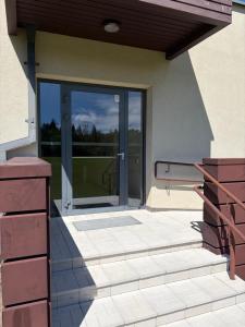 a glass door of a house with a porch at Kambarių nuoma in Utena