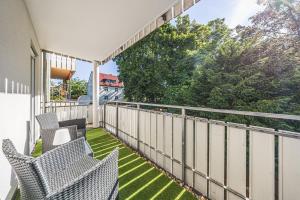 a balcony with two chairs and a fence at Design Apartment Leipzig Airport DHL Amazon Voll ausgestattet Free Parking in Schkeuditz