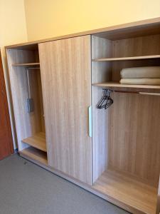 a wooden cabinet with wooden shelves in a room at Kambarių nuoma in Utena