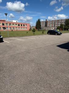 a parking lot with two cars parked in front of a building at Kambarių nuoma in Utena +2 photos