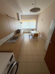 a kitchen and dining room with a table and chairs at Kambarių nuoma in Utena