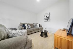 a living room with a couch and a tv at Relax and Rejuvenate in Vermont