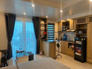 a room with a bed and a desk and a kitchen at Tâm An Luxury Hotel in Ninh Lão
