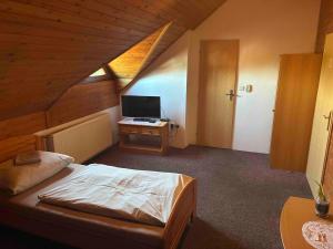 a bedroom with a bed and a desk with a television at Hostinec U Havlů in Olomouc