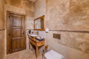 a bathroom with a wooden door and a sink and a toilet at Karis Cave Cappadocia in Ürgüp +100 photos