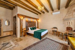 a bedroom with a bed and a table in a room at Karis Cave Cappadocia in Ürgüp