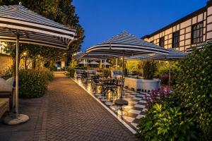 a patio with tables and chairs under umbrellas at ANEW Hotel Hilton Pietermaritzburg in Hilton