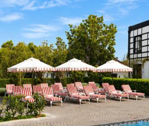 a group of chairs and umbrellas in a courtyard at ANEW Hotel Hilton Pietermaritzburg in Hilton