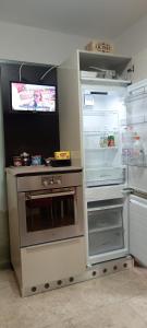 a kitchen with an open refrigerator and a television at B&B Casa dolce casa in Cutrofiano