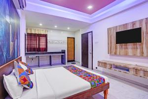 a bedroom with a bed and a flat screen tv at FabHotel Saptshrungi in Nashik +19 photos