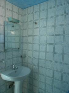 Baño blanco con lavabo y espejo en Blue White House en Kalamitsi