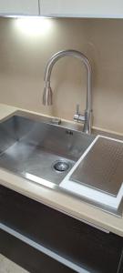 a kitchen counter with a sink with a laptop on it at B&B Casa dolce casa in Cutrofiano