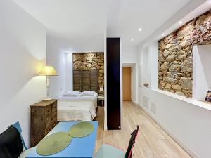 a bedroom with two beds and a stone wall at COCON HYPER CENTRE-VILLE TOUT CONFORT (8) in Ajaccio