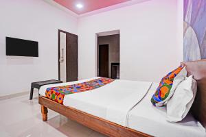 a bedroom with a bed and a television in it at FabHotel Saptshrungi in Nashik