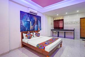 a bedroom with a bed in a room with a piano at FabHotel Saptshrungi in Nashik