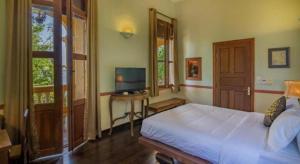 a bedroom with a bed and a television in it at Le Relais de Chhlong in Chhlong