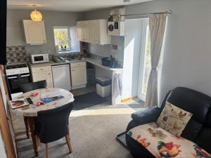 a kitchen and living room with a table and a couch at Barfad Self Catering Holiday Cottages in Tarbert