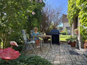a woman sitting at a table in a garden at Ferienhaus Klöber in Lichtenhain