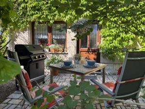 a patio with a table and a stove and chairs at Ferienhaus Klöber in Lichtenhain