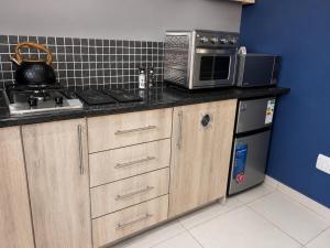 a kitchen with a counter top with a microwave at Kairos Guesthouse in Thabazimbi