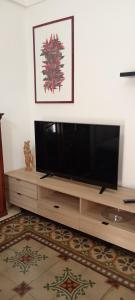 a flat screen tv sitting on top of a wooden entertainment center at B&B Casa dolce casa in Cutrofiano