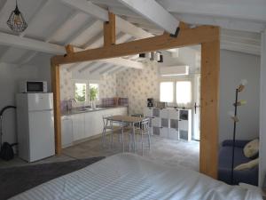 a bedroom with a bed and a kitchen with a table at Le chalet de la tranquillité ! in Parignargues