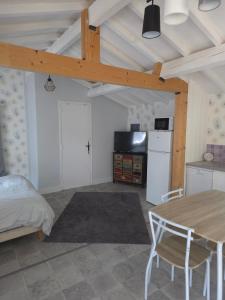 a living room with a table and a kitchen at Le chalet de la tranquillité ! in Parignargues