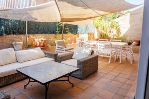 a patio with a couch and chairs and a table at Beachfront chalet in Valencia in Valencia
